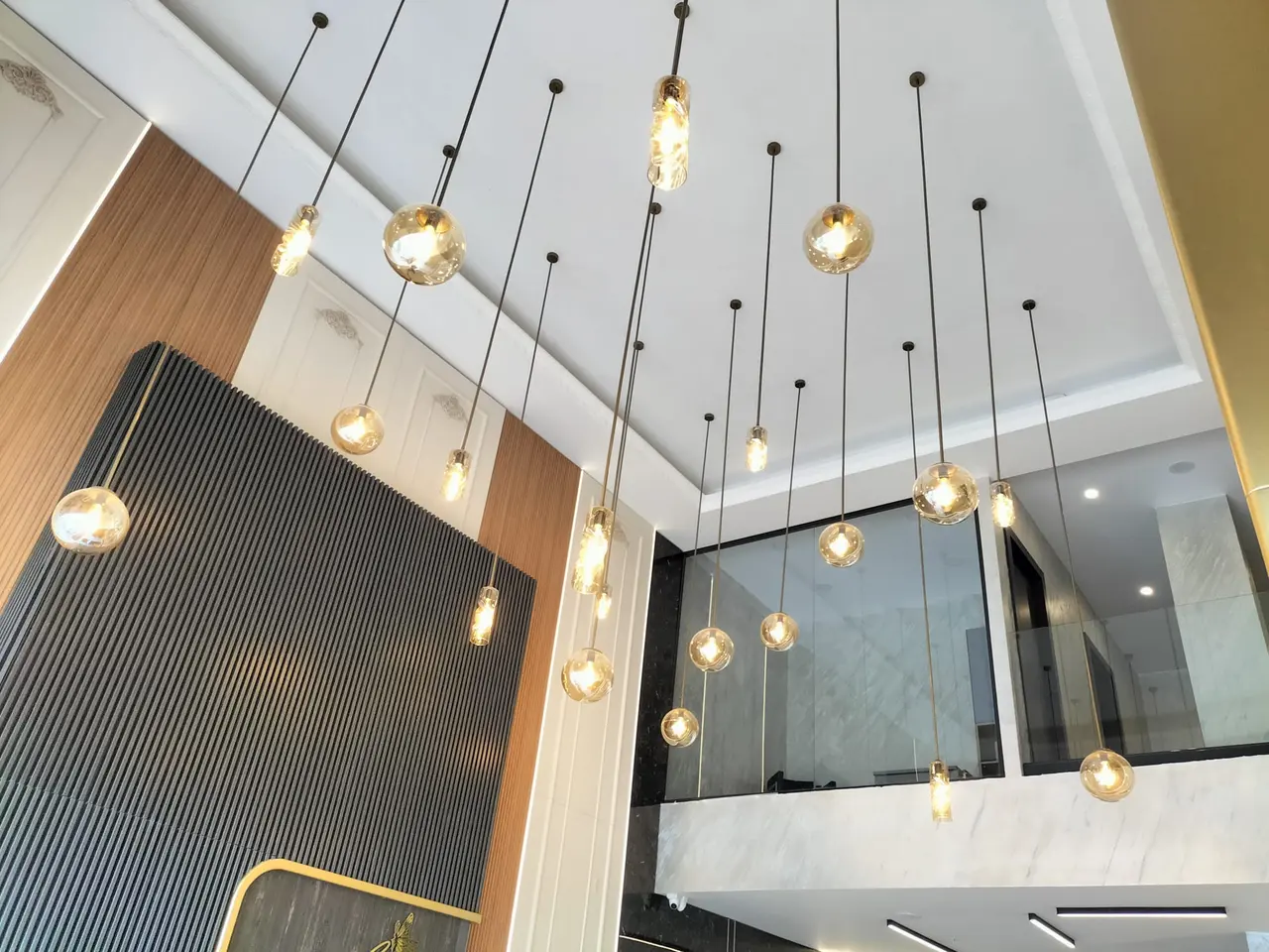 Elegant Craft-ın Elona Salon interyeri: qara mərmər, qoz lamellər və şüşə çıraqlar